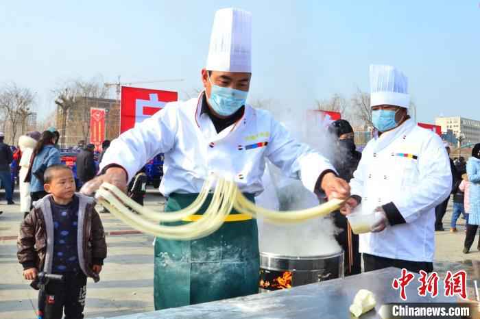 图为活动现场的面匠正在做拉面。 鲁丹阳 摄 青海“拉面之乡”千人共享幸福面 1.7万余家拉面店创造130亿年产值