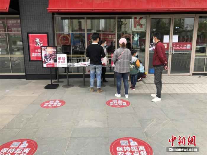 距武汉约60公里的孝感,是武汉之外全国疫情第二重的城市。随着疫情形势好转,孝感逐步取消封闭管控、全面恢复区域内交通出行。图为3月24日,湖北孝感一家快餐店门口,顾客在门店外排队凭号取餐。中新社记者 梁婷 摄 探访湖北孝感:小城渐寻烟火气 返岗复工正当时